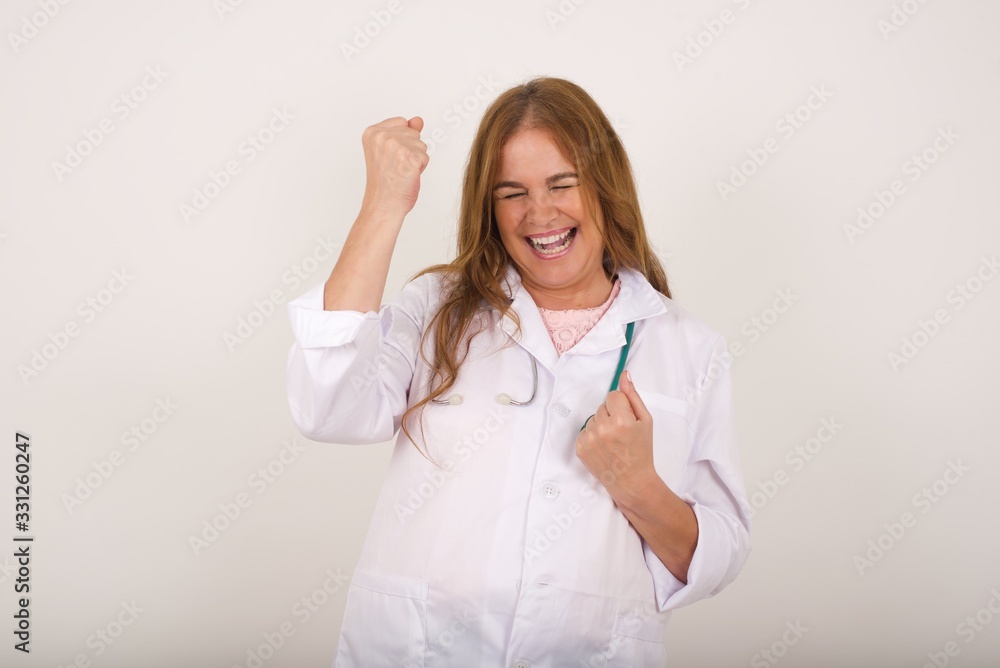 Beautiful doctor woman happy and excited expressing winning gesture. Successful and celebrating victory, triumphant. Beautiful doctor woman happy and excited expressing winning gesture. Successful and celebrating victory, triumphant.