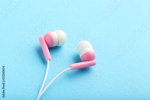 Pink earphones on blue background