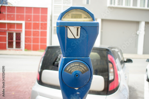 Blue vintage parking meter with a car in the background in Willemstad, Curacao