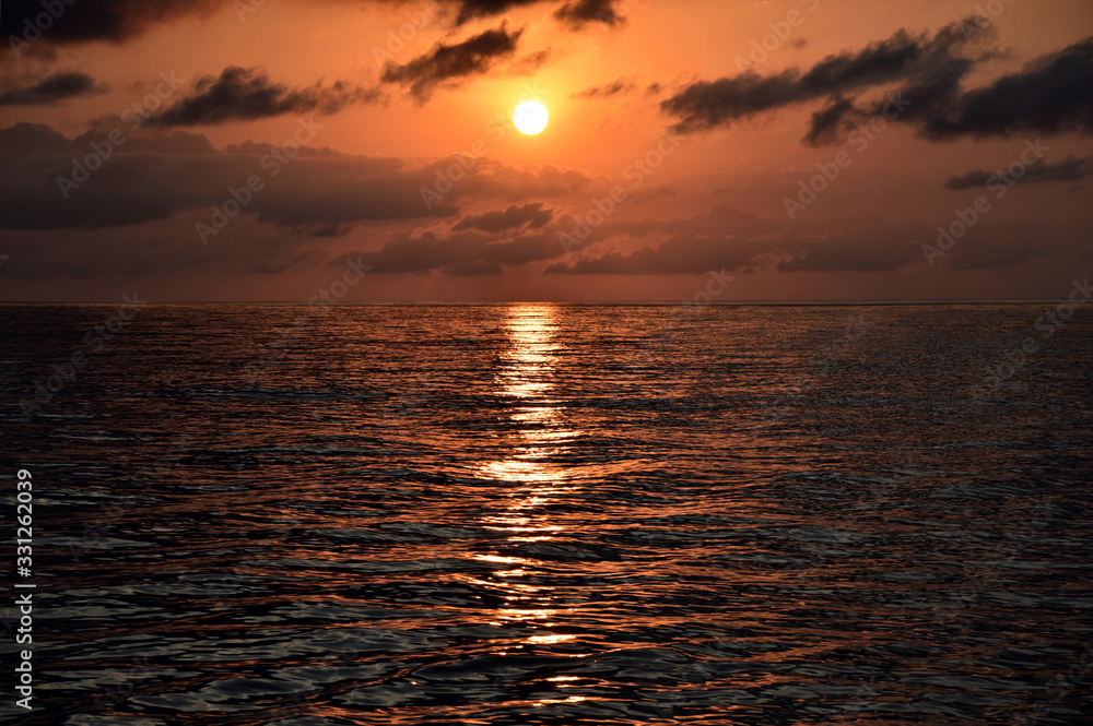 Obraz premium Panorama of beautiful sunset and evening clouds over the calm ocean.