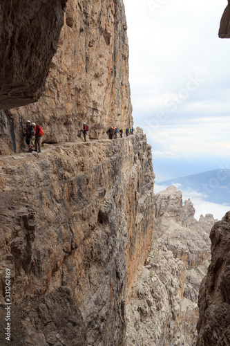 People climbing on via ferrata Sentiero delle Bocchette Centrale in Brenta Dolomites mountains, Italy