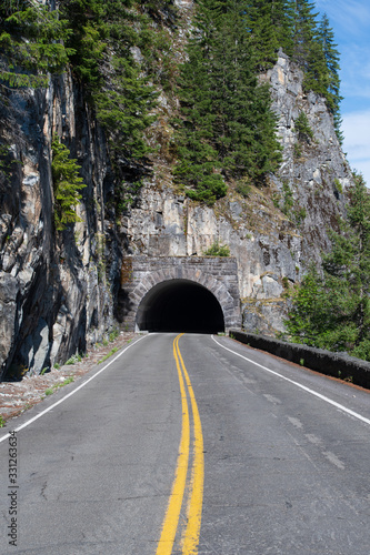 Straight road leading to a dark tunnel at Mount Rainier National Park in Washington, USA