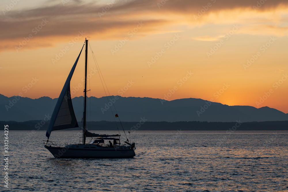 Small sailboat at sunset on the Puget Sound in Seattle, Washington, USA