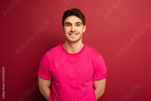 portrait of smiling man in pink t-shirt on red