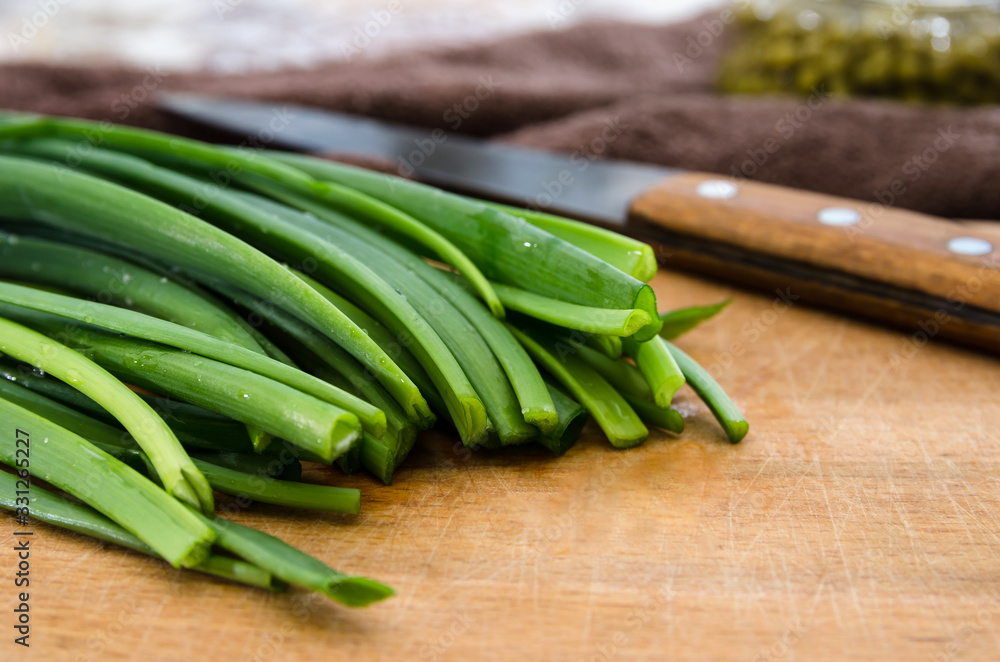 green onion and knife on wooden board. Close-up. green onion and knife on wooden board. Close-up.