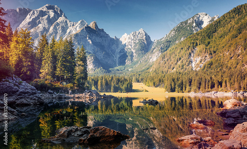 Awesome sunny landscape in the forest. Wonderful Autumn scenery. Picturesque view of nature wild lake. Instagram filter. Incredible view on Fusine lakeside. Amazing natural Background. creative image
