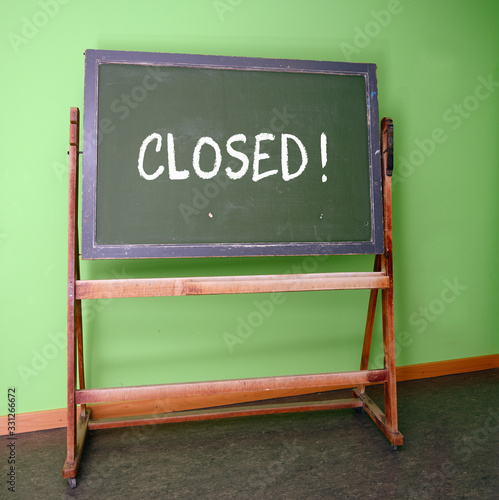 Closed written on an old school chalkboard to symbolize the closure of schools as preventive measure during the risk of infection with the curonavirus photo