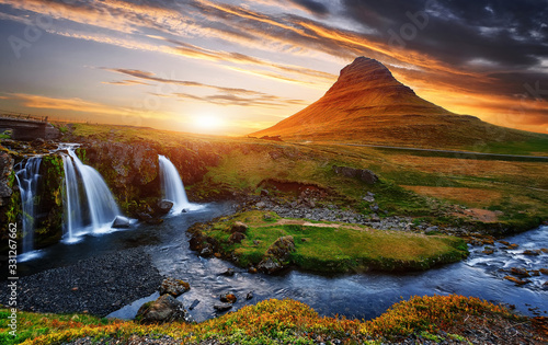 Gorgeous Colorful sunset over the Kirkjufell mountain landscapes and waterfalls. Iceland. Most beautiful mountain in Iceland during amazing sunset with waterfall Kirkjufellsfoss (Grundarfjorour).