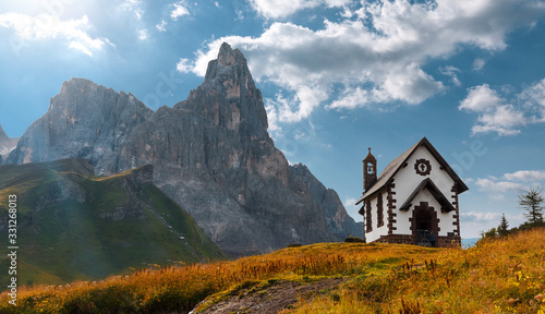 Summer mountain scenery in the Dolomites. Beautiful sunny landscape. The Dolomite Mountains and the small Christian church in the foreground