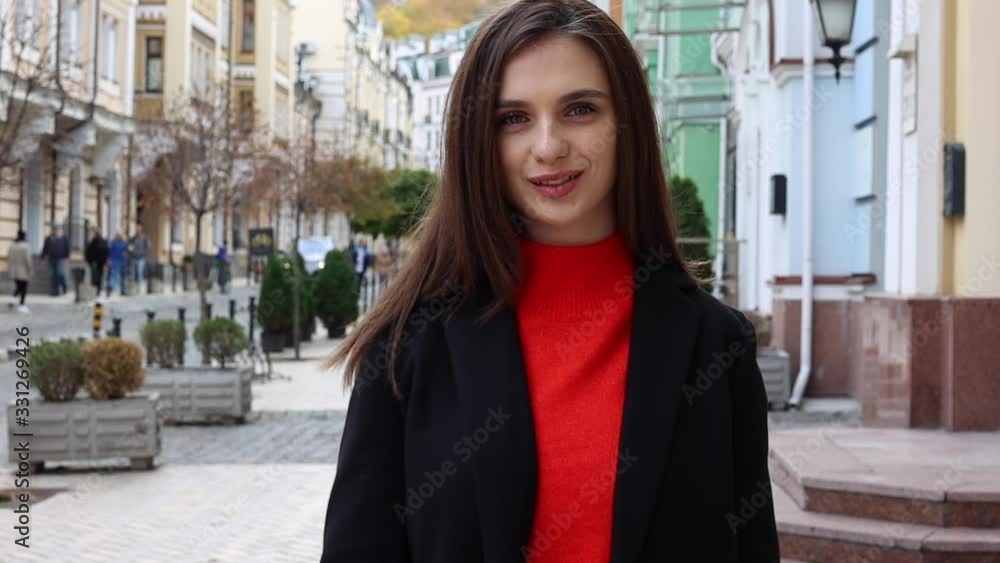 A young woman turns around and smiles. Girl on the background of the city. A young woman turns around and smiles. Girl on the background of the city.
