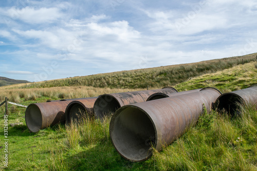 Rusty large water pipes lying on a moor