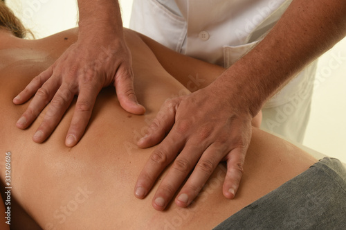 Masseur doing massage on woman body in the spa salon 