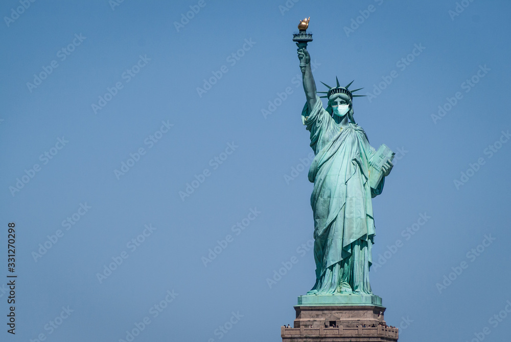 Statue of liberty wearing a surgical mask. Concept of Coronavirus, COVID-19, isolation, protection and quarantine Statue of liberty wearing a surgical mask. Concept of Coronavirus, COVID-19, isolation, protection and quarantine