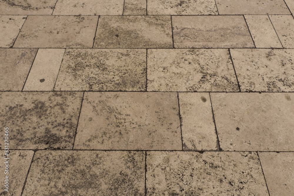 Naklejka premium Tiles on a sidewalk made of white Travertine marble 
