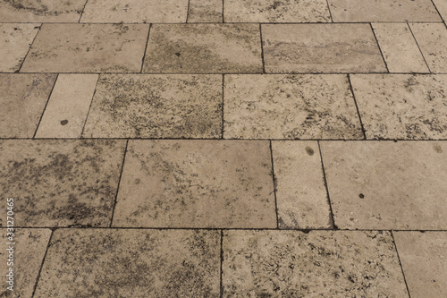 Tiles on a sidewalk made of white Travertine marble 