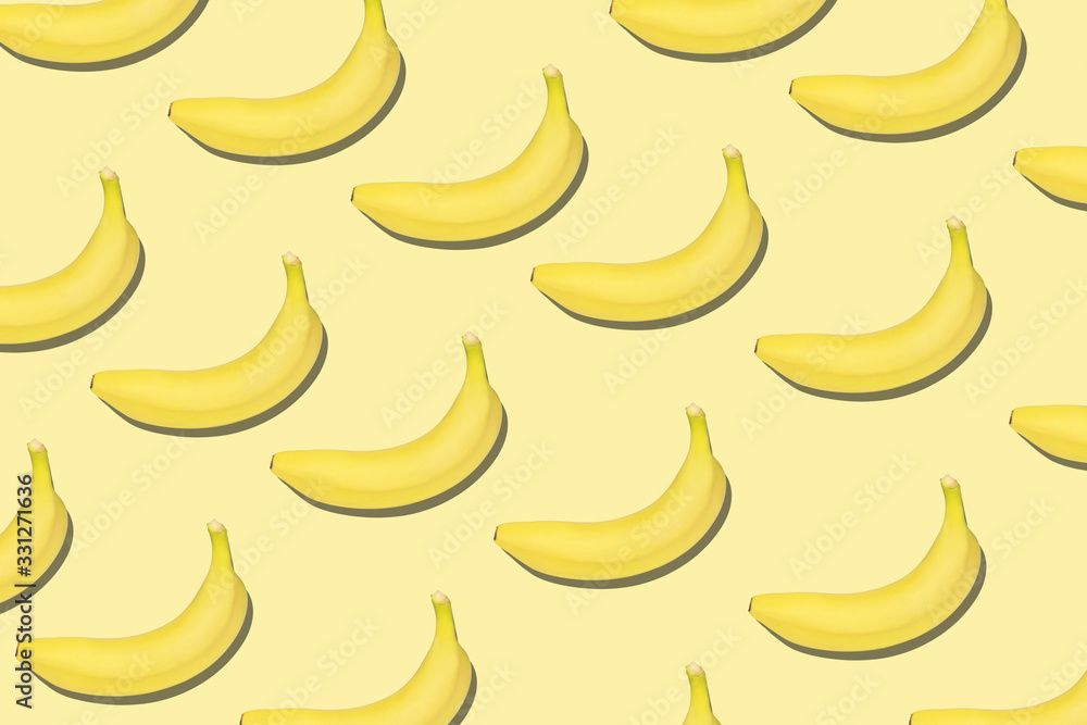 Colorful fruit pattern of fresh yellow bananas on yellow background.