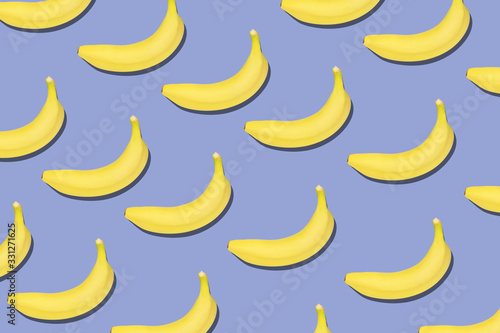 Colorful fruit pattern of fresh yellow bananas on blue background.