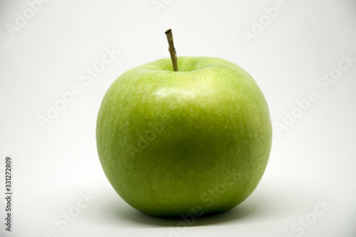 A green apple on a white background - lateral view