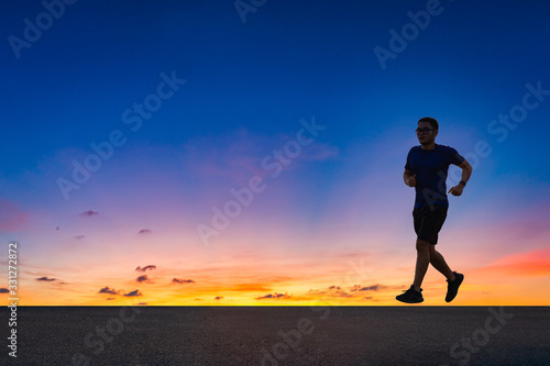 Man running sprinting on road. fit male fitness runner during outdoor workout with sunset background © background photo