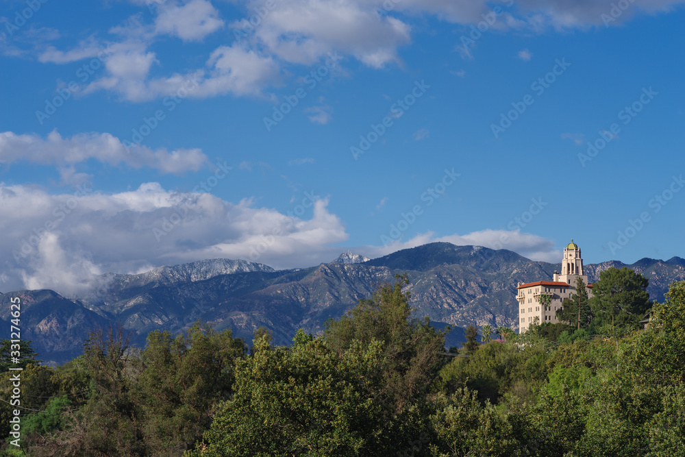 The landmark courthouse of appeals building overlooking the Arroyo Seco in Pasadena, San Gabriel Valley, and snow dusted mountains in the background.
