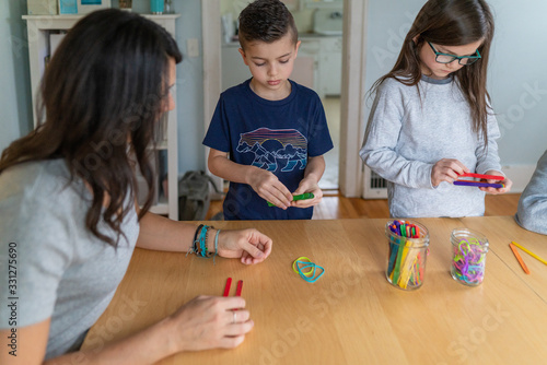 Children building catapults with popsicle sticks and rubberbands as part of a homeschool STEM lesson photo