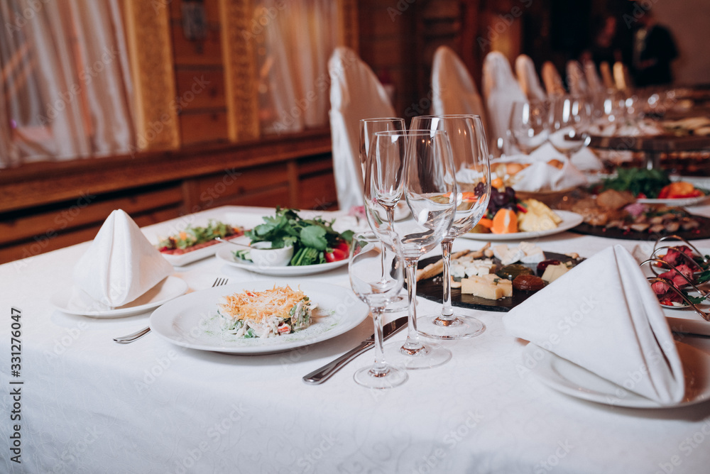 a table in the restaurant served with food and glasses a table in the restaurant served with food and glasses