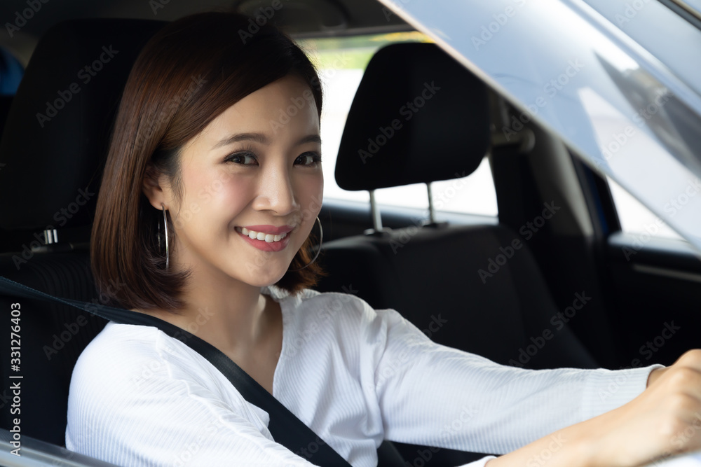 Asian women driving a car and smile happily with glad positive expression during the drive to travel journey, People enjoy laughing transport and relaxed happy woman on roadtrip vacation concept Asian women driving a car and smile happily with glad positive expression during the drive to travel journey, People enjoy laughing transport and relaxed happy woman on roadtrip vacation concept