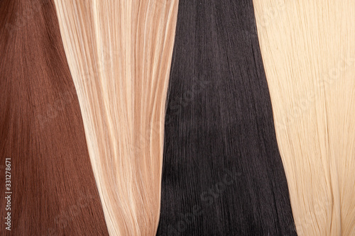 Long hair extensions in natural colors. Black, brown, blonde, and blonde balayage. photo