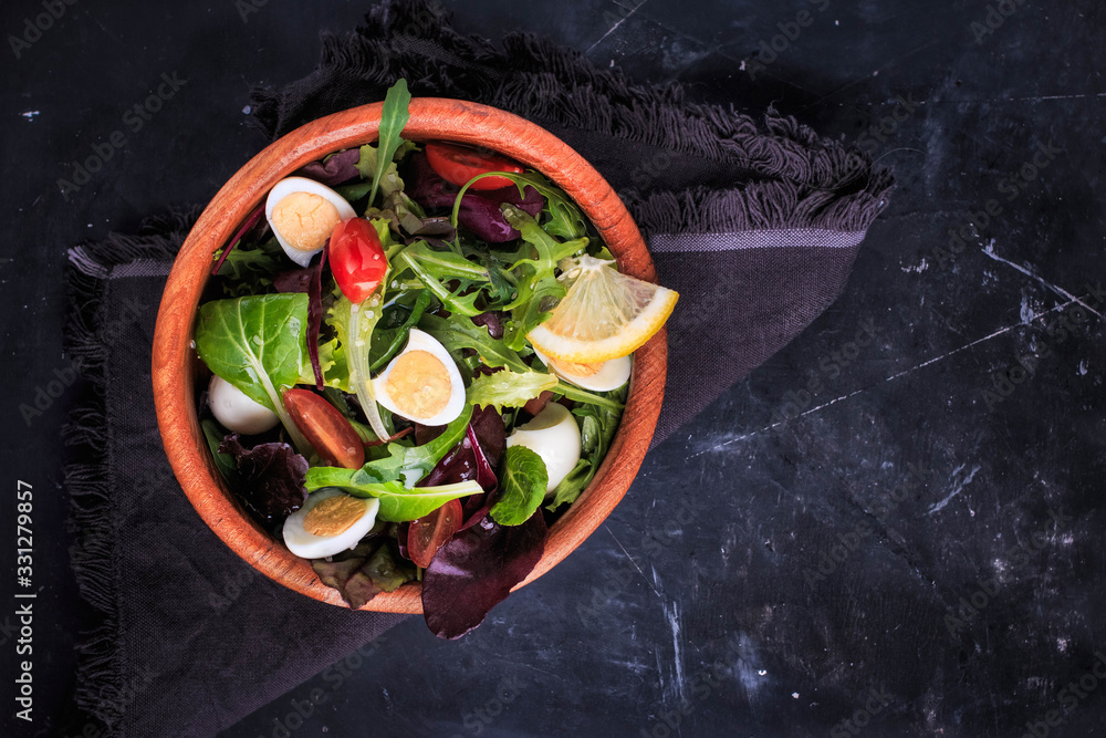 Spinach Salad. Healthy fresh salad with tomatoes and eggs in a wooden bowl.
