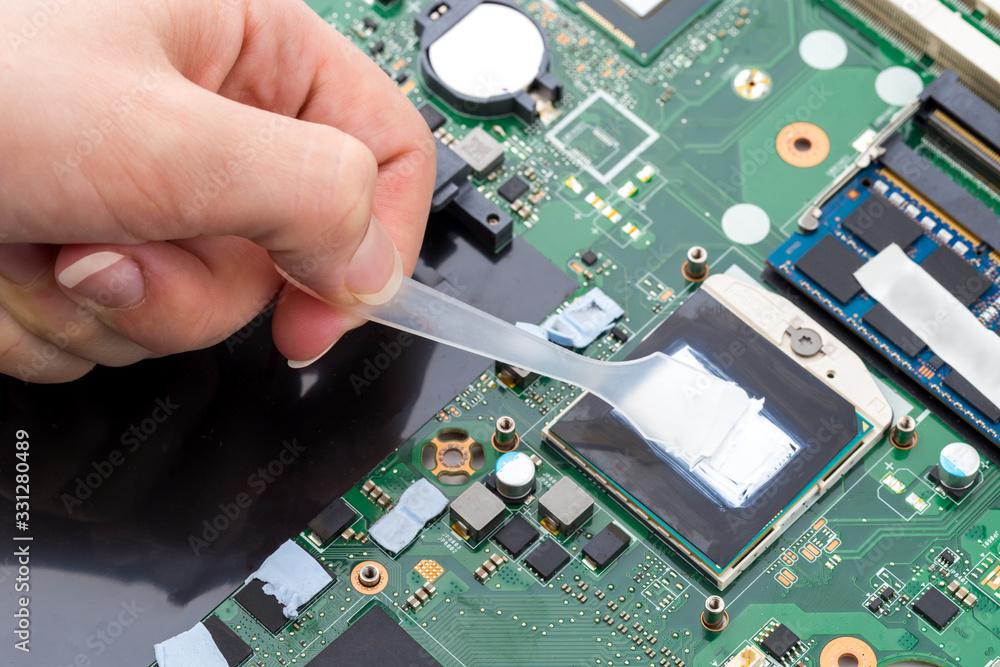 Replacing thermal paste on a laptop. Applying thermal paste to the laptop processor. Stock Photo