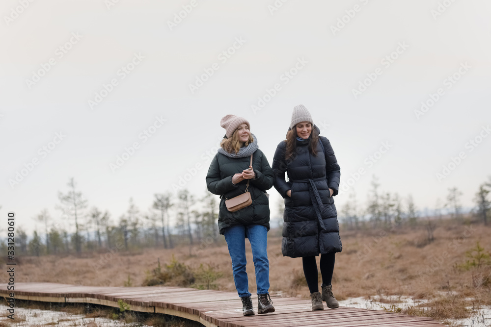 Two friends walk in the woods. Girls relax in nature