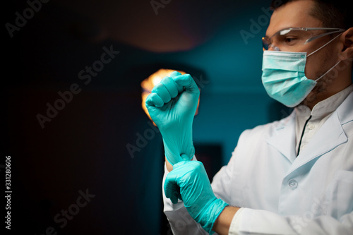 closeup scientist or Doctor wearing protective glove in lab