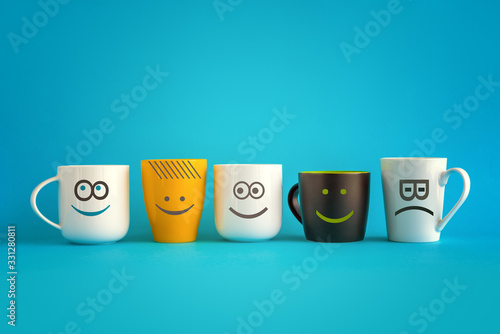 Coffee Cups with Happy and Sad Emoticons photo