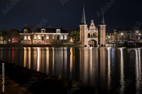The famous historical 'Waterpoort' in the city of Sneek at night with reflections in the canal - Sneek, Friesland, The Netherlands © fotografiecor