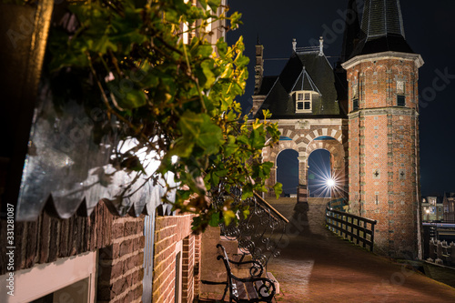 The famous historical 'Waterpoort' in the city of Sneek at night from a stunning side view - Sneek, Friesland, The Netherlands photo