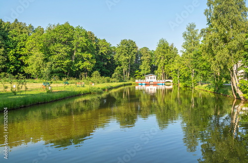 Picturesque pond in park with gazebo on shore