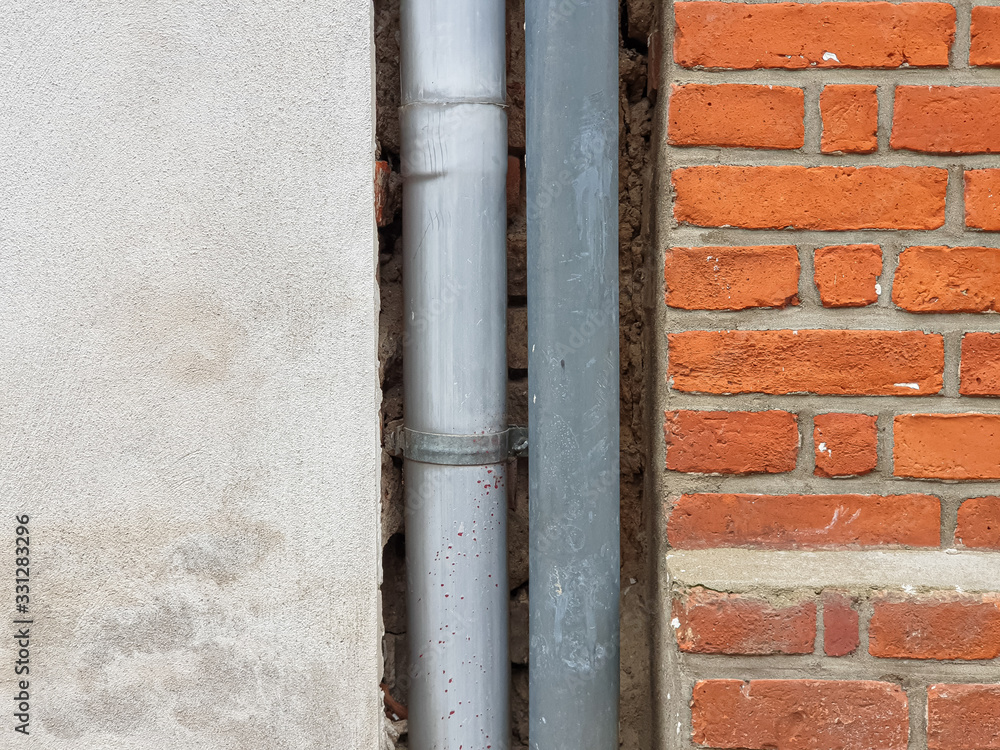 Background texture of stone wall made of bricks and a gutter Background texture of stone wall made of bricks and a gutter