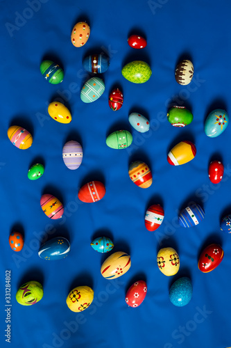 multicolored wooden eggs on blue background