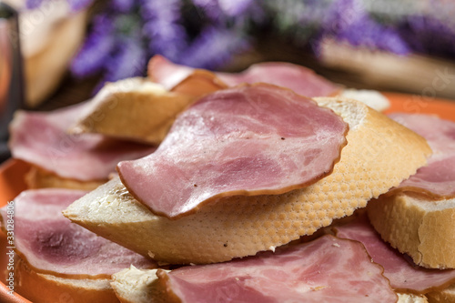 Sandwich made of wheat bread, butter and slices of dry-cured sausage.