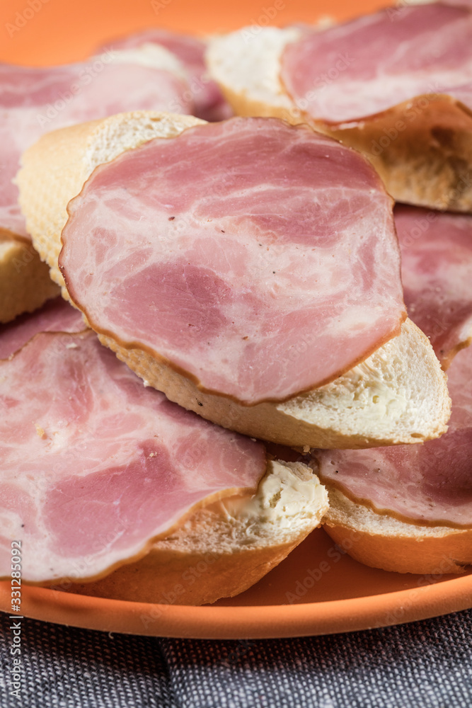 Sandwich made of wheat bread, butter and slices of dry-cured sausage. Sandwich made of wheat bread, butter and slices of dry-cured sausage.