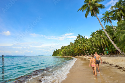 Couple walking at famous "White beach" next to City of Port Barton, Palawan, Philippines © marako85
