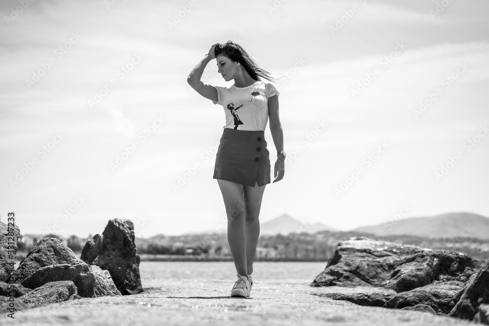 Street style, a pretty brunette portrayed near the coast in black and white