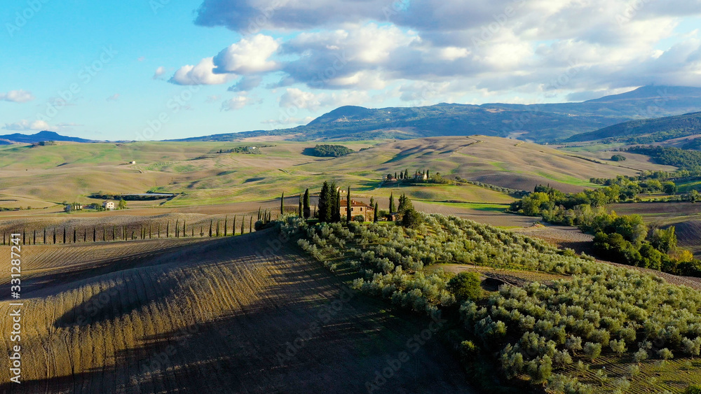 Naklejka premium Panorama of a landscape with meadows in Tuscany Italy, with mountain in the background, aerial view
