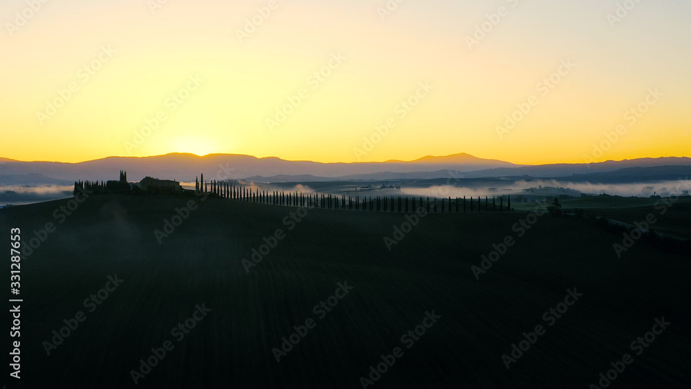 Fototapeta premium Beautiful landscape scenery of Tuscany in Italy - sunrise with fog in aerial view 