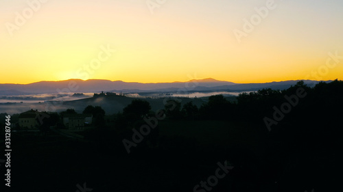 Beautiful landscape scenery of Tuscany in Italy - sunrise with fog in aerial view 