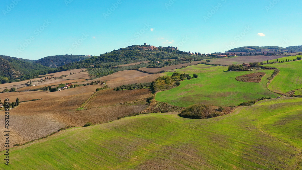 Italian village of Monticchiello in Tuscany, Italy. Drone flying over the magnificent village and green meadows. Perfect for authentic travelling in Italy	