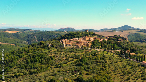 An Italian village with green meadows all over the village. Aerial view with a drone of the beautiful and old village of Monticchiello in Tuscany  Italy 