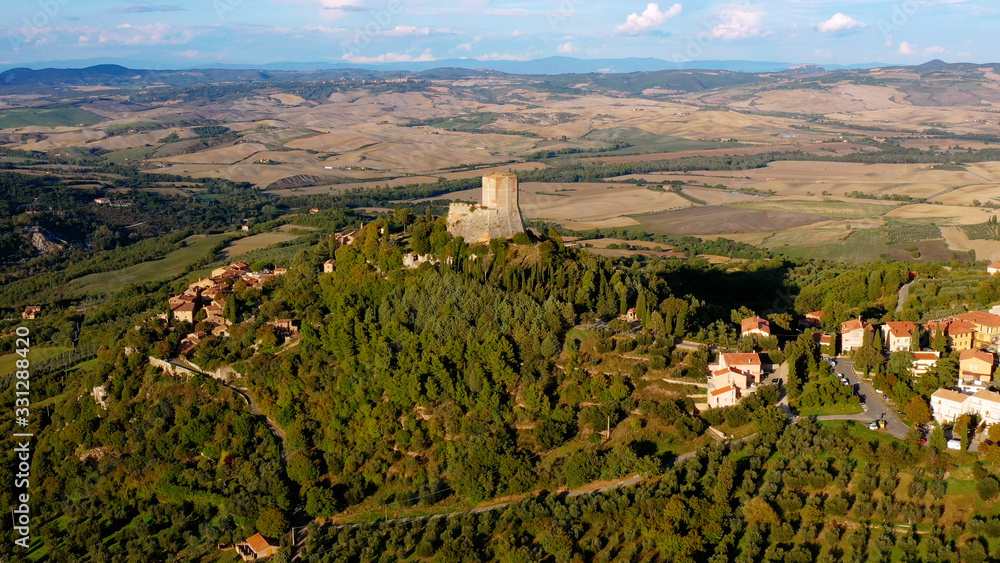 Obraz premium Aerial view with a drone over a magnificent authentic Italian village and green meadows. Beautiful old village of rocca d'orcia Tuscany, Italy. Perfect for travel and vacations