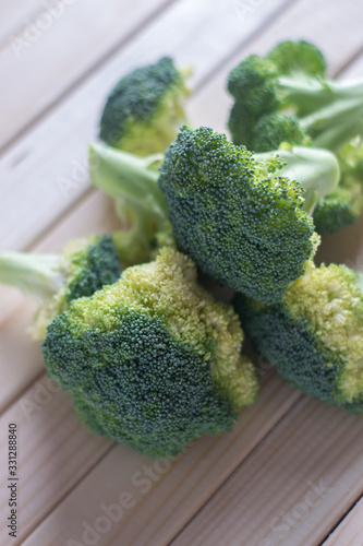 green healthy broccoli on light wood
