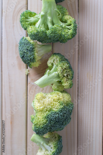 green healthy broccoli on light wood
